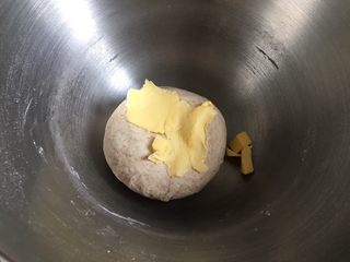 4、黄桃全麦披萨,然后启动厨师机中速挡，搅拌成团，加入软化的黄油，继续启动厨师机揉面