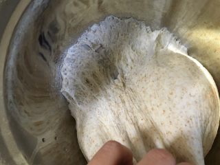 8、黄桃全麦披萨,取出发酵好的面团，有两种检查方式，一是拉一下面团，有蜂窝状的孔；二是可以用手指沾一点面粉戳一下面团，孔不会回缩即可。