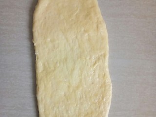 9、超软白米粥吐司,取松施好的面团用擀面仗擀成椭圆形。