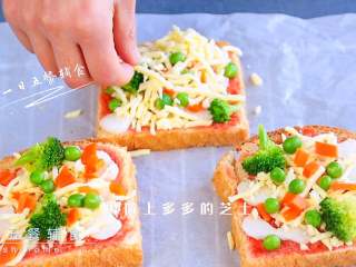 4、吐司披萨,摆上西蓝花、胡萝卜粒、豌豆，再撒上多多的芝士。