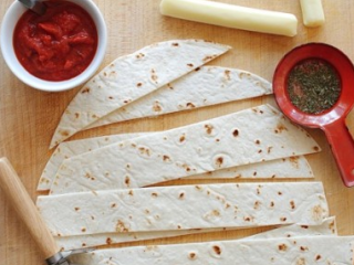 1、比萨卷饼,用披萨刀，将玉米饼片均匀地切成条。