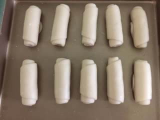 15、咸蛋黄鲜肉月饼,卷起来,卷好之后,收口朝上,盖上保鲜膜,松驰15分钟