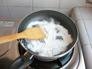 11、冰皮豆沙月饼,蒸好的粉糊先晾着，先来炒手粉，锅烧干，放入少许的糯米粉，微火炒2~3分钟即可