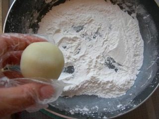 17、冰皮豆沙月饼,把冰皮月饼胚放到手粉里蘸一下