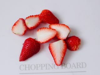 3、紫薯双米草莓粥,把草莓洗净后,用刀把草莓蒂切去不要,再把草莓一切两开。