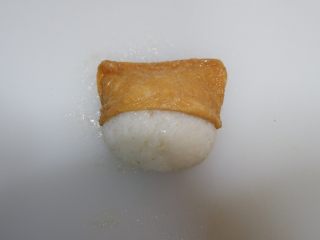 7、卡通睡帽小熊便当「13」,打开做好的饭团，将豆腐包套在饭团上。睡帽小熊就完成了。