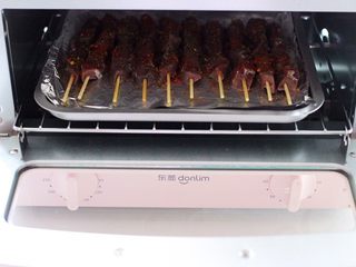 13、孜然香辣烤猪腰串,烤箱180度提前预热5分钟后,把烤盘放入烤箱中层。