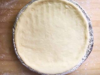 4、意式四季披萨,用手按压成圆饼胚放入披萨盘里。