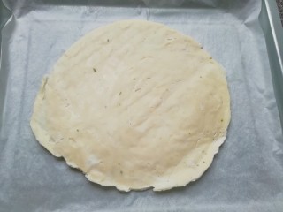 6、手抓饼披萨,烤盘里铺上油纸，放上一张手抓饼饼胚(无需解冻)。