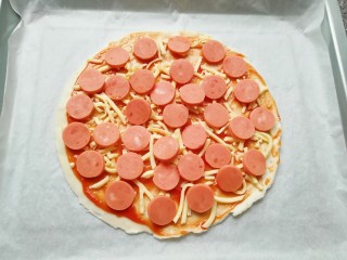 9、手抓饼披萨,铺上一层火腿肠。