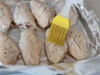 6、柠檬黑胡椒烤鸡翅,腌制好的鸡翅中摆放在烤盘上，在表面再薄薄刷一层油。九阳的这款12L烤箱自带的烤盘摆放12个翅中刚刚好