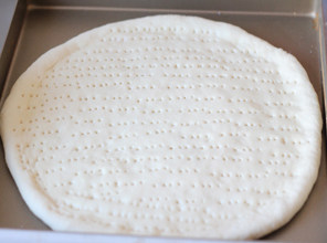 16、打造paty上超实惠的大披萨——金枪鱼披萨 ,再次醒发20分钟左右，用叉子叉孔透气，以免烤的时候鼓起来。