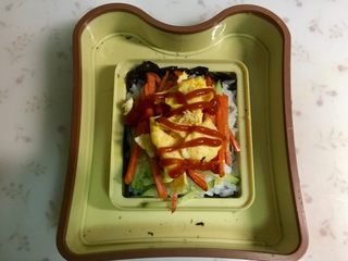 8、米饭三明治,放入鸡蛋碎，挤上番茄酱。