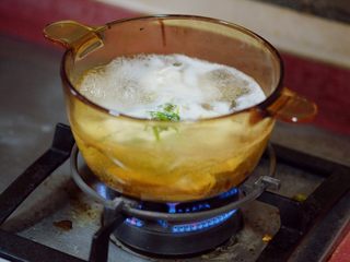 9、香辣秋葵手撕鸡,水沸腾后,火转中火,以水不会扑出来,保持小沸腾为准。再煮10分钟,用筷子戳鸡肉,能轻易撕开鸡肉,就可以捞起,放入凉水浸泡,降温