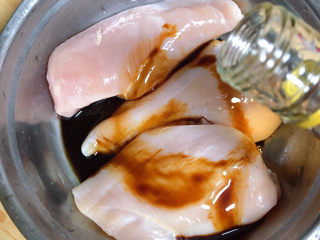 3、照烧鸡胸肉,再倒入料酒。