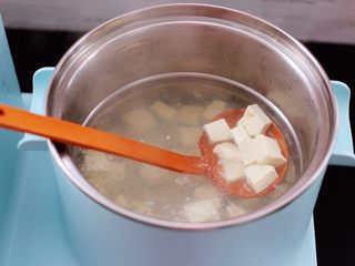 2、虾皮翡翠白玉羹,东菱早餐机的汤锅里，加入适量的清水烧热后，放入豆腐焯水后，捞出沥干水分备用。