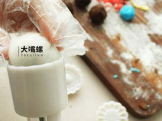 20、Q萌红糖冰皮月,包好后的冰皮红豆沙裹一层熟糕粉，放入模具中压紧实，顺着模具压就完成了