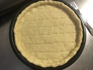 9、秘制芝心卷边披萨,卷好固定好收口。表面扎些眼防鼓起。