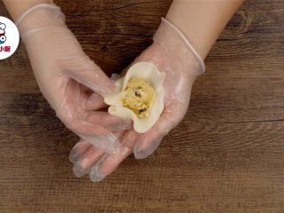 4、三款零难度免烤月饼,取适量揉好的面团搓圆压扁，放入冰淇淋球，收口搓圆