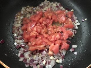 6、火腿虾仁披萨,然后倒入洋葱粒炒香，然后倒入西红柿翻炒