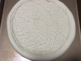 15、火腿虾仁披萨,再次发酵的披萨饼，用叉子在饼中间扎上小孔