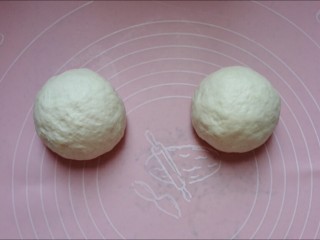 8、馅料足足的超级至尊匹萨,取出面团,按压排气后分成两个相同大小的面团,滚圆,盖上保鲜膜静置15分钟。