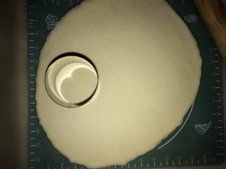 8、披萨包,用圆模压出圆形,取出放入烤盘。