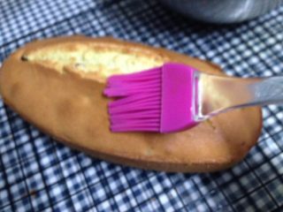 15、蔓越莓磅蛋糕,然后在晾至温热的蛋糕表面均匀的刷满糖浆，用保鲜膜包好后放入冰箱冷藏过夜即可