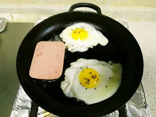 4、三明治,平底锅煎入鸡蛋、放入午餐肉片。