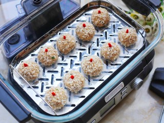 14、冬至美食 清香可口的珍珠藕丸,电蒸锅的水箱中加满水,将丸子放入蒸锅,每一个丸子上插一粒枸杞,盖上锅盖大火蒸20分钟即可。