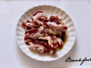 4、百吃不厌的双椒炒肉,把切好的五花肉加5克料酒，2克淀粉，10克花生油，1克盐和1克白糖混合搅拌均匀后腌制10分钟。