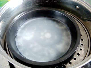 4、锦鲤寿司,转动盘子使糊糊均匀的铺满盘底，上锅盖上盖子，一分钟左右，蒸至完全透明就熟了。