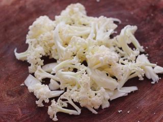 3、菜花番茄海虾小炒,把有机菜花用刀切成小朵。