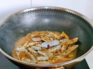 9、爆炒蛏子,加入一汤勺纯净水，大火快速翻炒。