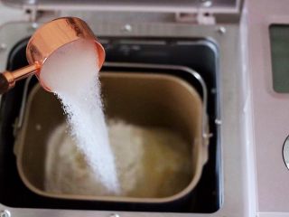 3、海虾杂蔬披萨,首先把面粉加入面包机里,把酵母用温水化开后,再分次倒入白砂糖和盐。