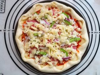 13、墨鱼热狗芝心披萨,先撒一层芝士，再放入所有馅料食材，再铺上一层芝士。