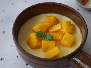 10、一次就成功的芒果牛奶布丁,蒸熟的牛奶布丁????放一旁晾凉，放上切好的的芒果丁。