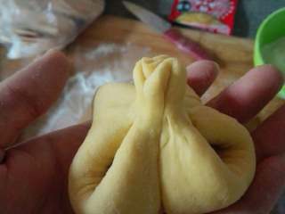 5、糖粽子,提着糖粽子，转圈捏紧。但是千万不要捏太大力了，把上面的面团给揪下来