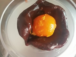 9、广式月饼,取一个馅料压扁放一个咸蛋黄包好，然后逐个包好。