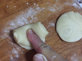 8、月饼节活动，苏式榨菜鲜肉月饼,静置好的面卷用手指在中间往下按压，让两头翘起，然后用手掌压成饺子剂子的样子擀成饺子皮状，包上馅料，依次码入烤盘。