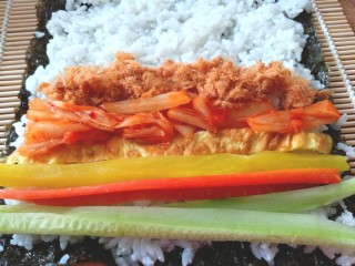 19、辣白菜肉松寿司卷,摆上黄瓜条，胡萝卜条，调味萝卜，辣白菜，肉松