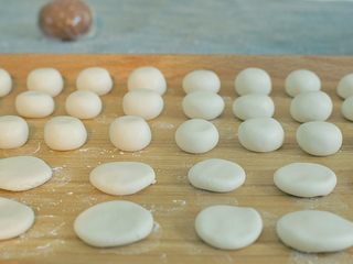 4、 熊猫汤圆,把大面团等分、搓圆为玻璃珠大小，一半压扁。