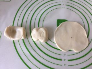 11、鲜肉月饼,取一个面团中间位置按一下,两头折到中间位置轻按一下,用擀面杖擀成圆片。