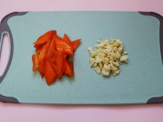 2、荷兰豆笔管蛸小炒,胡萝卜洗净后用刀切成薄片，把大蒜切成碎末。