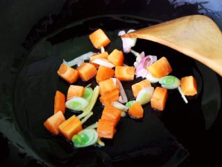 7、茼蒿肉末营养羹,锅烧热后,先爆香葱姜再放入胡萝卜丁翻炒片刻。