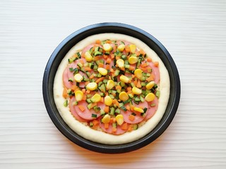 9、火腿彩蔬披萨,均匀的撒上黄瓜丁、胡萝卜丁和熟玉米粒。