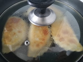 17、韭菜盒子,盖上盖子，中小火焖1分钟，盒子鼓起就好了。