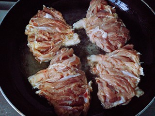 6、照烧鸡腿,油烧至8成热时，转中小火。将腿肉带皮那面放入锅中，这一步的目的是为了先将鸡皮煎定型。