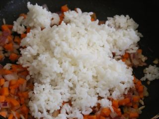 7、日式蛋包饭,放入蒸好的米饭，继续翻炒均匀。