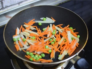 4、火腿披萨,锅中油热，加入洋葱，豌豆胡萝卜，炒两分钟